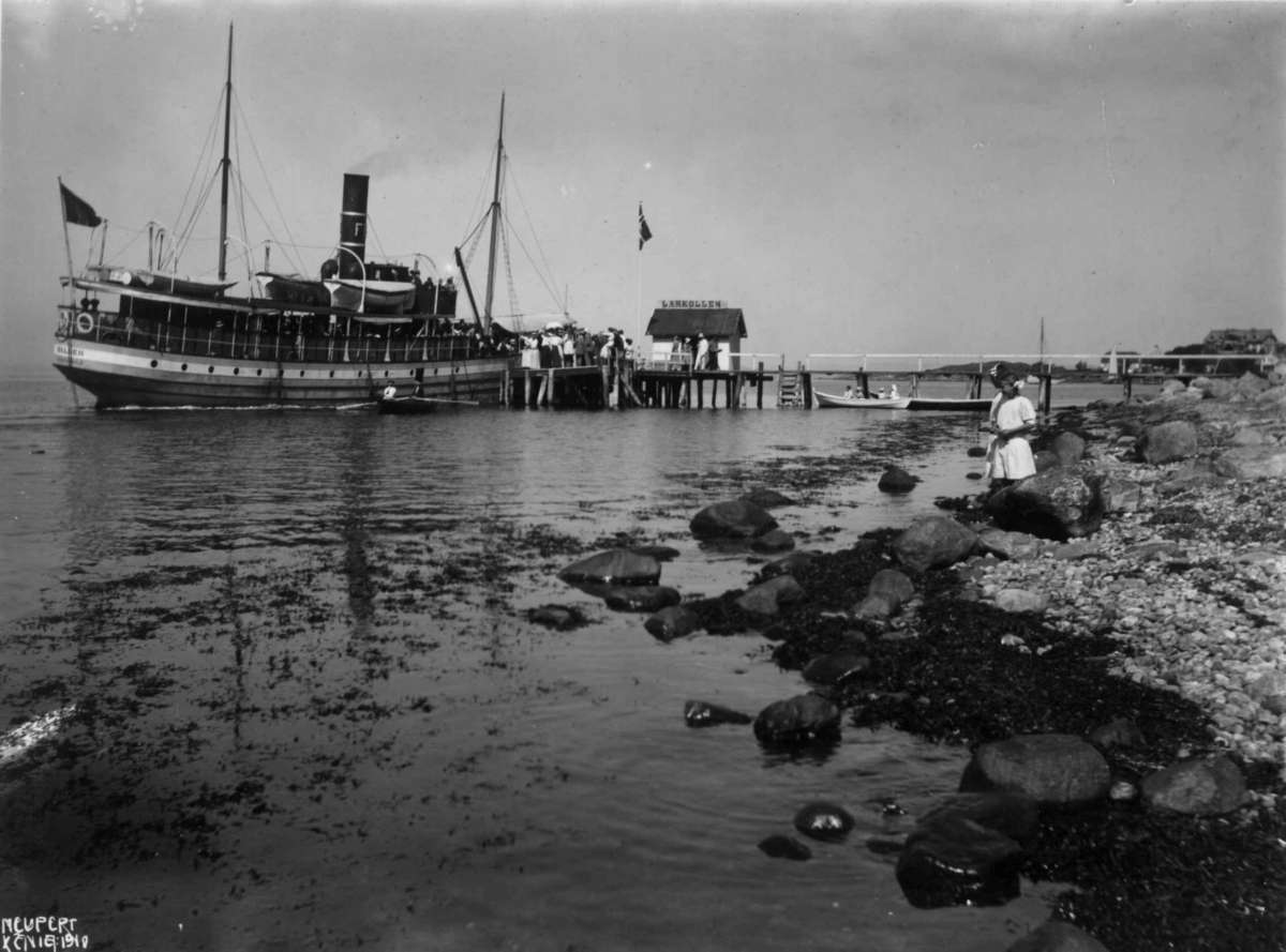 Hermann Christian Neupert, Dampbåten "Halden" 1910. Larkollen - Rygge - Østfold. Brygge. Robåter. Passajerer. Et barn leker i fjæra. Foto Neupert. Platen er dat. aug. 1910.