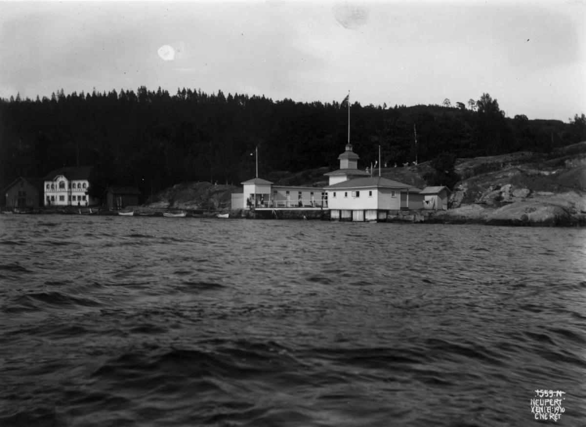 Hermann Christian Neupert, Drøbak bad, Akershus 1910. Badehus og brygge. Båter.