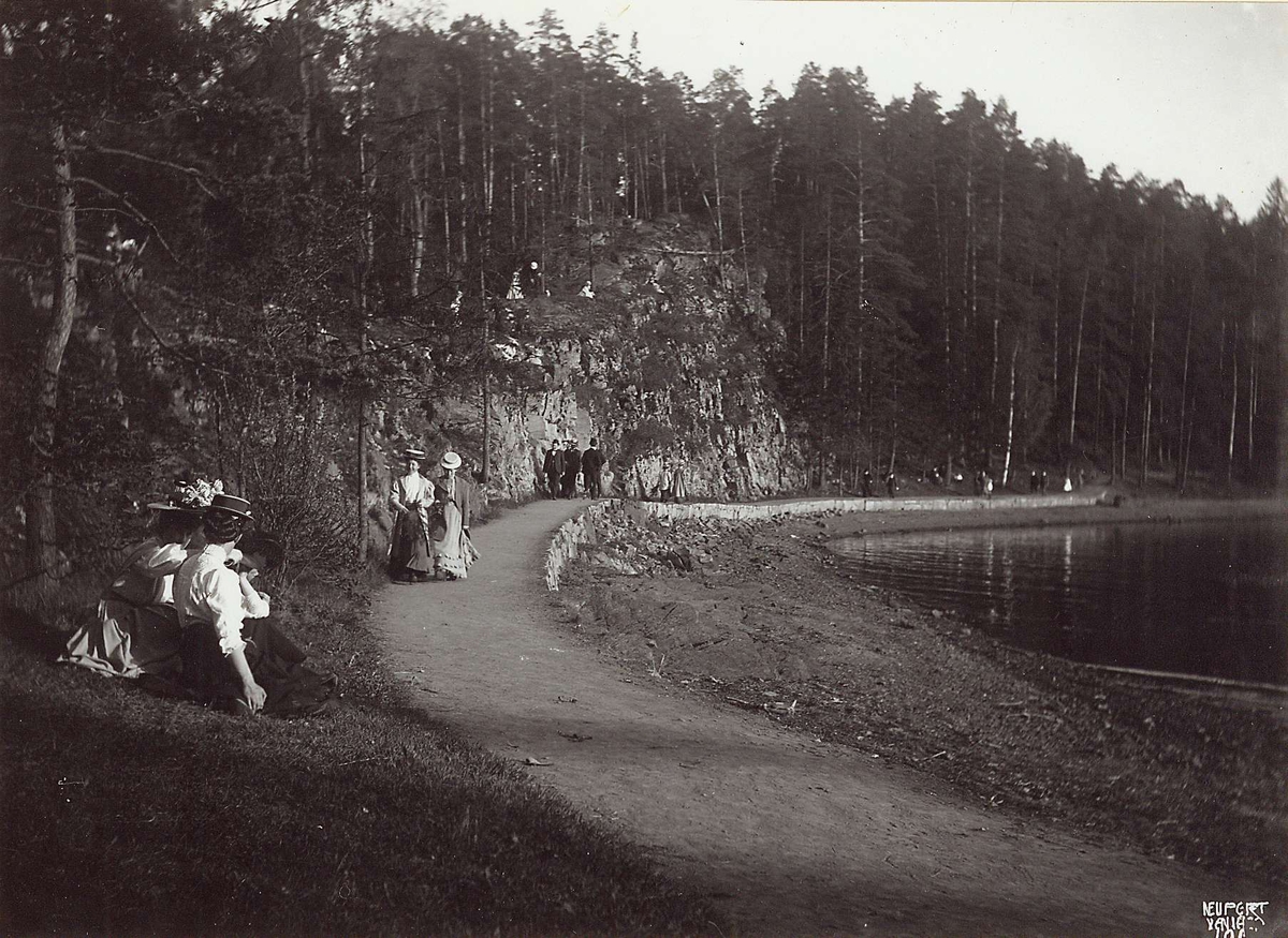 Hermann Christian Neupert, Ved Bygdøy Sjøbad, Oslo 1908. Mennesker spaserer på veien langs stranda.