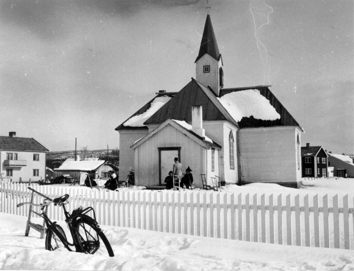 Virginia Raymond Davidson, Mennesker og sparkstøtter utenfor Karasjok kirke, vinter 1958.
