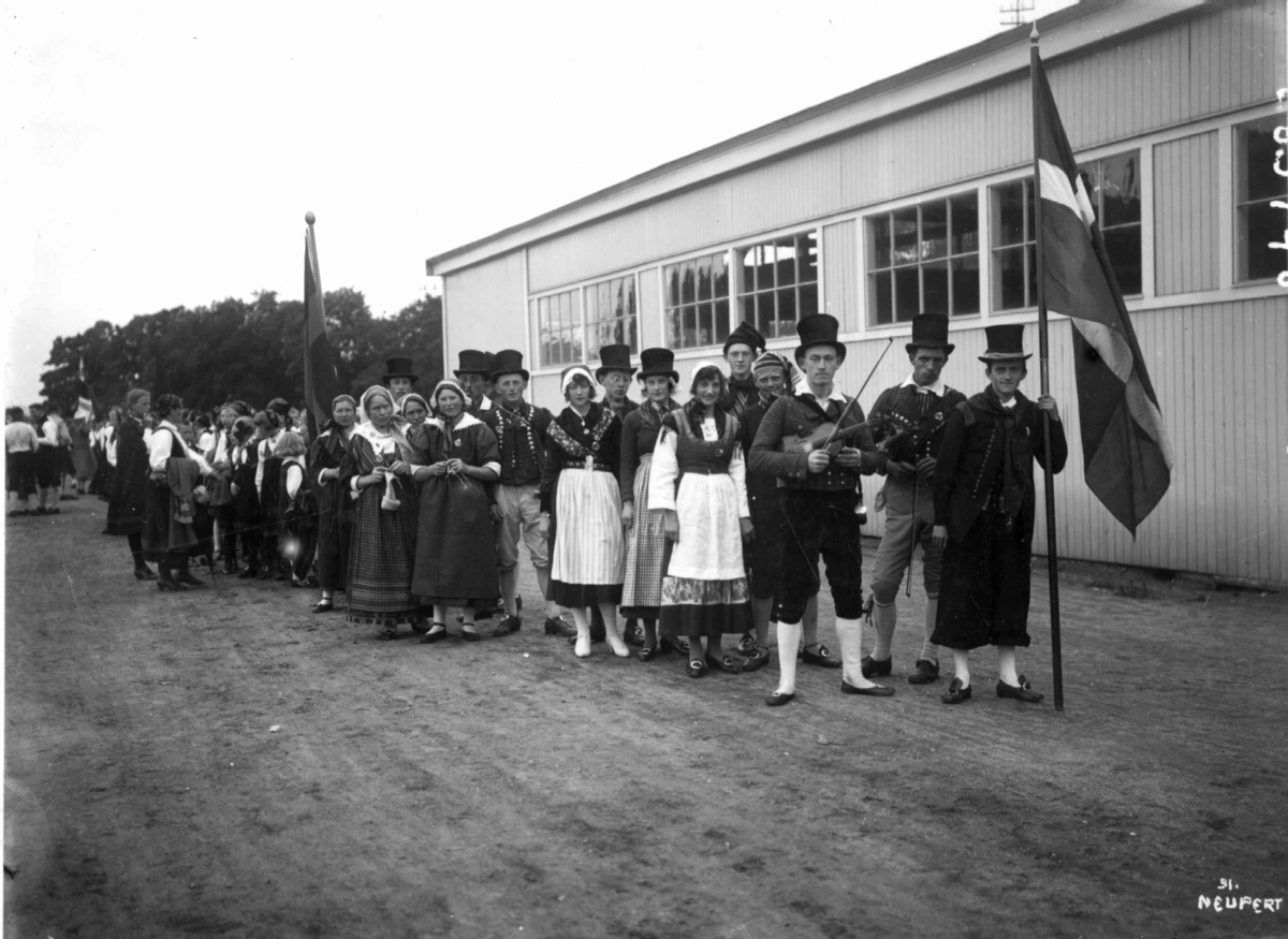 Hermann Christian Neupert, Nordisk Folkedansstevne ant Frogner stadion - Oslo. 1925. Opptog av ant. danske folkedansere foran Norges Varemesse. Flagg.