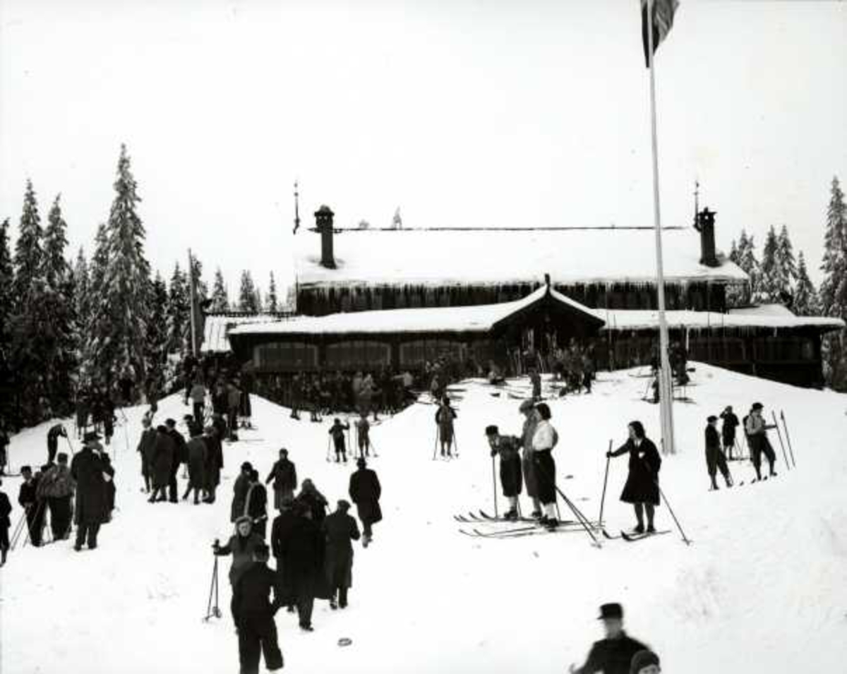 Hermann Christian Neupert, Frognerseteren Restaurant, Nordmarka, Oslo. Vintermotiv. Skiløpere foran restauranten.